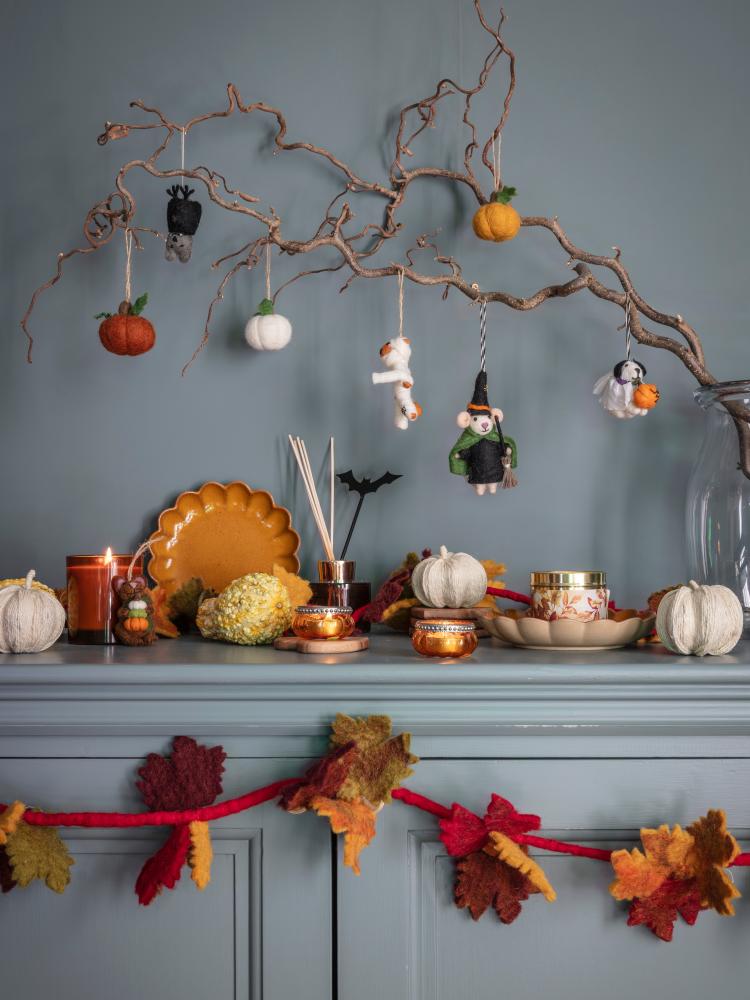 National Trust Halloween decorative accessories, including felt hanging ornaments, a felt garland and decorations on a sideboard