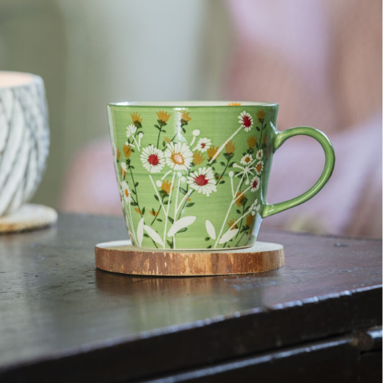 National Trust green daisy mug on a wood coaster.