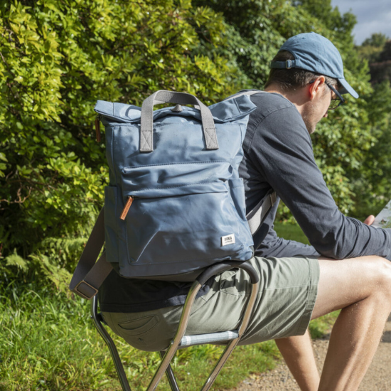A man carrying a ROKA Canfield B Medium Airforce Navy Backpack