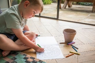 Childrens activity & craft kits - image shows two children playing with The Original Den Making Kit, surrounded by nature. Both are contructing an awning using the tools provided by the Den Kit.