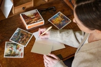 Image shows Notecards and notebook on a duck egg blue wooden chair