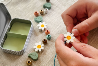 Childrens activity & craft kits - image shows two children playing with The Original Den Making Kit, surrounded by nature. Both are contructing an awning using the tools provided by the Den Kit.