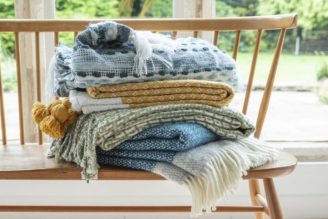 Throws & blankets - image shows the Jacquard Leaves Throw paired with the Illusion Red Throw on a windowsill, with pampas grass adding a natural touch to the home decor.