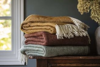 Throws & blankets - image shows the Jacquard Leaves Throw paired with the Illusion Red Throw on a windowsill, with pampas grass adding a natural touch to the home decor.