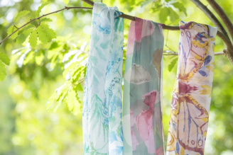 Scarves - image shows model wearing the Hinton Ampner inspired scarf from the new National Trust autumn winter range.