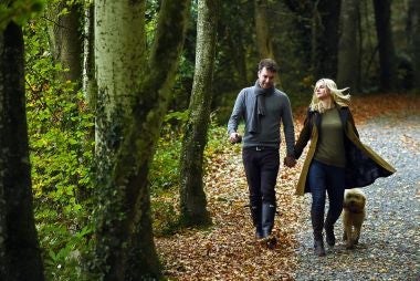 Gifts for friends & couples - image shows a couple in a National Trust garden in spring, with flowers in bloom.