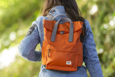 ROKA London Backpacks in blue and green on a sideboard with a Roka London umbrella
