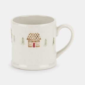 Cream ceramic mug with an embossed textured finish, featuring a festive gingerbread house and pine tree pattern in soft brown, green and red tones, with a curved handle and classic cylindrical shape.