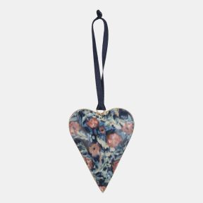 Metal heart-shaped hanging decoration featuring the Cotehele print, with an artistic floral design in shades of blue, pink, and cream. Finished with a dark blue ribbon loop for hanging, ideal for seasonal displays, home décor, or gifting.