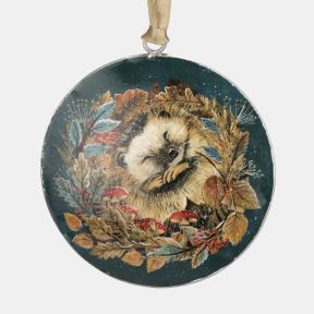 Round Christmas hanging decoration featuring an illustrated sleeping hedgehog surrounded by autumn leaves, red berries and woodland mushrooms on a deep teal background, shown in a close-up view with a champagne-coloured hanging ribbon.