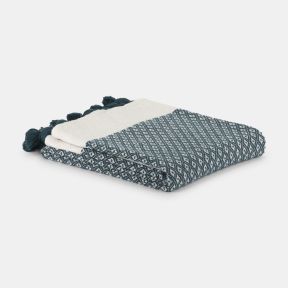 Folded woven throw blanket in teal and cream, featuring a geometric diamond pattern and decorative teal tassels along the edge. Soft textured fabric displayed neatly folded against a light grey background.