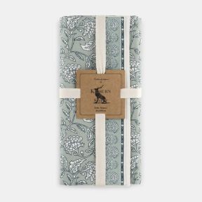 Kilburn & Scott Table Runner in soft sage green, featuring an elegant heritage-inspired floral and bird print with decorative border detailing. Folded and secured with presentation straps, this fabric table runner combines classic country charm with a mut