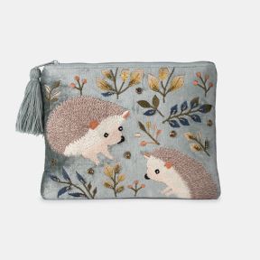 Light blue velvet cosmetic pouch with embroidered hedgehog design, featuring woodland leaves, berry motifs, bead embellishments, zip-top closure, and decorative tassel pull.