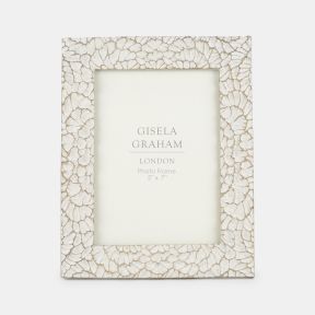 Decorative photo frame featuring an intricate shell-inspired mosaic pattern in soft cream tones with subtle distressed detailing. Designed to display a 5" x 7" photograph, the textured frame adds natural elegance and coastal-inspired charm to shelves, sid