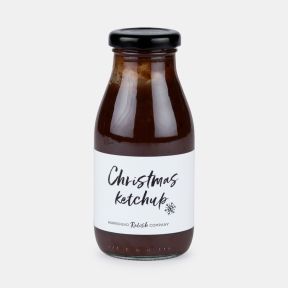 Bottle of Christmas ketchup from Hawkshead Relish Company, featuring a glass bottle with a black lid and a white label with handwritten-style text, filled with rich red ketchup and isolated on a white background.