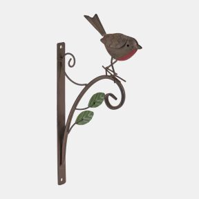 Decorative metal robin wall bracket featuring a rustic brown bird with a red breast perched on a curved scrollwork arm. The metal mounting bracket includes two green leaf accents and is designed for hanging baskets, lanterns, or garden ornaments.