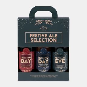 Festive ale selection gift set featuring three bottled beers: Christmas Day Hoppy Amber Ale, Boxing Day Golden Pale Ale, and New Year's Eve Traditional IPA, presented in a decorative carry box.