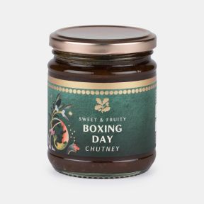 Jar of sweet and fruity Boxing Day chutney with a festive green label featuring seasonal botanical illustrations and the text “Sweet & Fruity Boxing Day Chutney”.