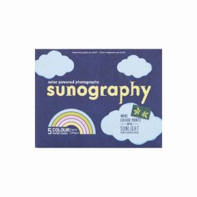 Front packaging of the “Sunography” solar‑powered photography kit, showing a dark blue design with cloud illustrations, the title “sunography,” a rainbow graphic indicating five colour paper cards, and text stating “Make colour prints with sunlight.”
