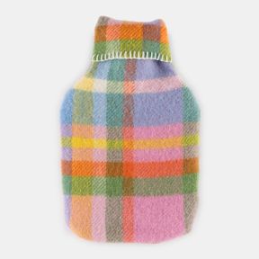 Hot water bottle covered in a soft woven fabric featuring a colourful pastel check pattern in rainbow tones. Finished with a matching collar and decorative blanket stitching, displayed against a plain light grey background.