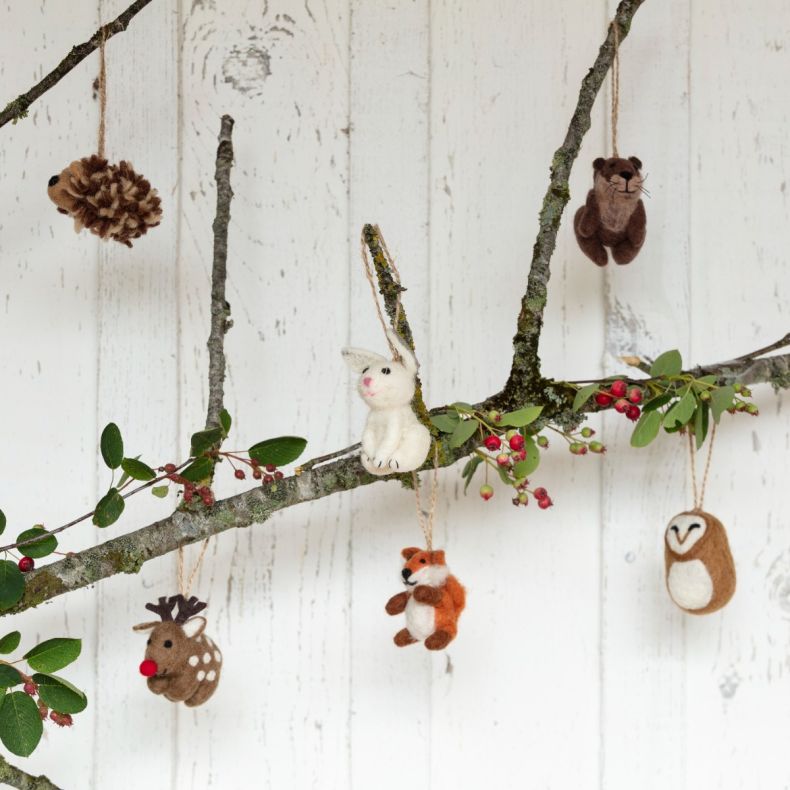 Felt woodland animal Christmas hanging decoration set displayed on natural branches, featuring handcrafted felt ornaments including a rabbit, fox, otter, owl, reindeer and pine cone, suspended from rustic twine loops and styled among berry-covered branche