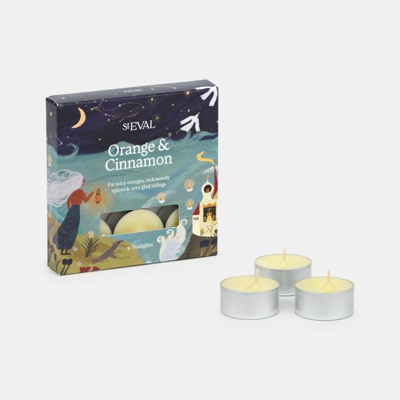 St Eval Orange & Cinnamon scented tealight gift pack displayed against a light background, featuring an illustrated cardboard box containing nine tealights and three loose tealights arranged in front. The packaging showcases a festive coastal-inspired sce
