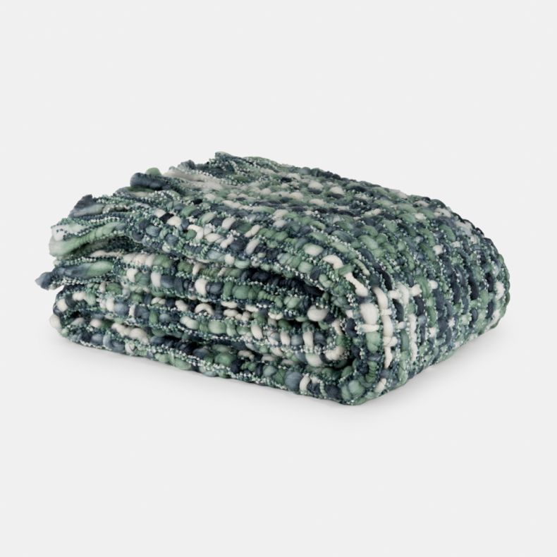 Folded green, blue and ivory chunky knit recycled throw with fringed edges.