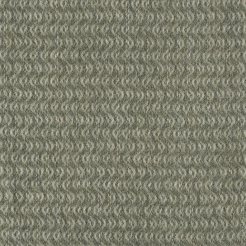 Close-up detail of a soft woven throw blanket in a muted sage green colour, featuring a repeating chevron-inspired wave pattern woven throughout the fabric. The image highlights the brushed texture, subtle tonal variations and intricate woven construction