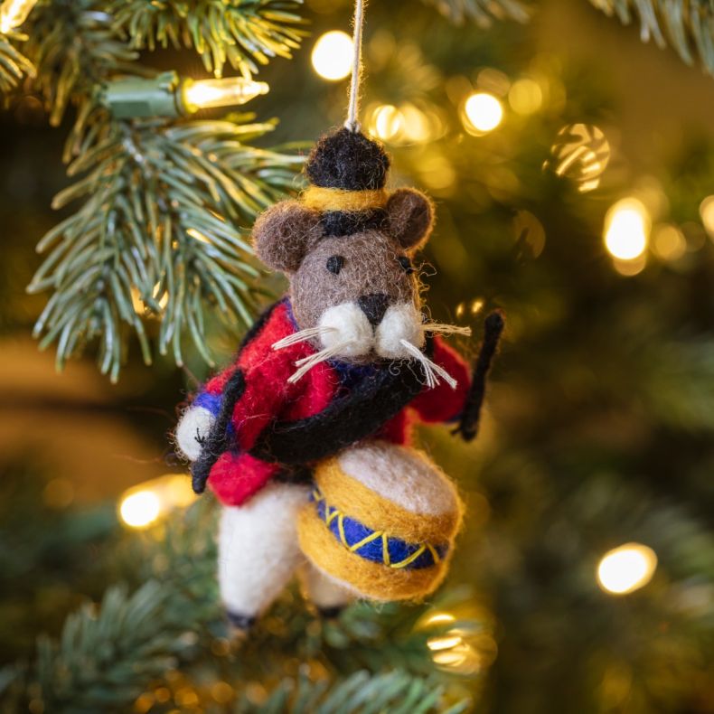Felt mouse drummer Christmas hanging decoration displayed on a Christmas tree, featuring a brown wool-effect body, black top hat with gold trim, red military-style jacket, blue and gold drum with drumsticks, white whisker detailing, and handcrafted needle
