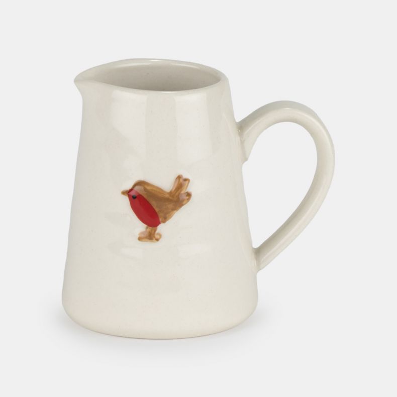 Cream ceramic milk jug with a curved handle and pouring spout, featuring a hand-painted robin motif on the front and a smooth glazed finish.