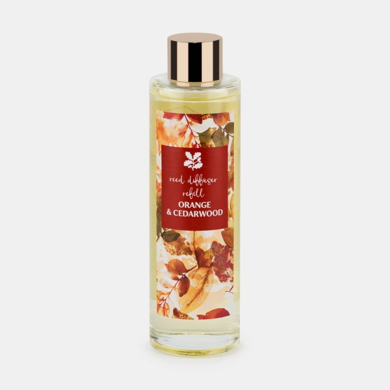 Orange & Cedarwood reed diffuser refill in a clear glass bottle filled with pale yellow liquid, featuring an autumn leaf-patterned label with a burgundy panel and a shiny gold-tone cap, displayed against a light background.