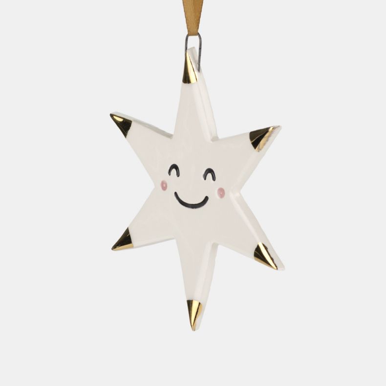 White ceramic star Christmas hanging decoration shown in a close-up view, featuring a smiling face with pink cheek details, gold-tone tipped points, a glossy glazed finish, and a gold hanging ribbon for festive seasonal décor.