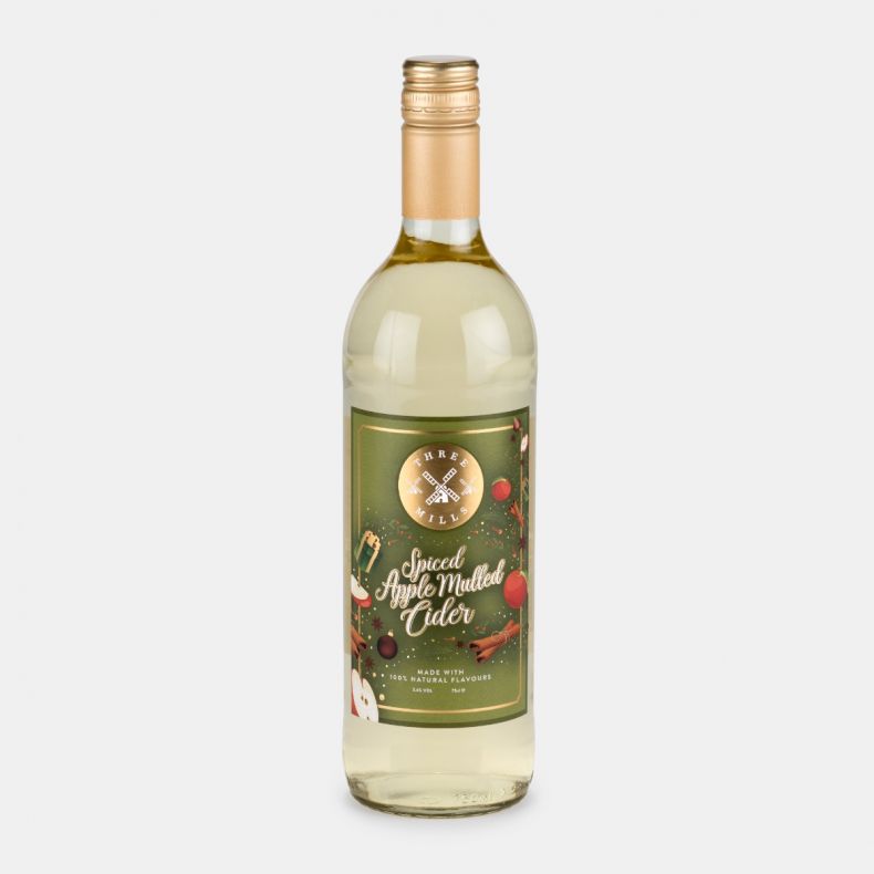 Three Mills Spiced Apple Mulled Cider in a 75cl bottle, featuring a festive green label decorated with apples, cinnamon sticks, seasonal ornaments and winter foliage illustrations.