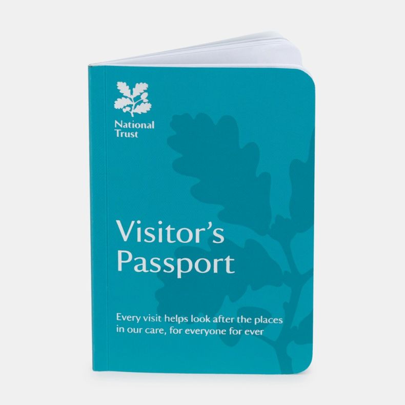 National Trust Visitor’s Passport booklet shown from an angled view, featuring a turquoise cover with the National Trust logo, white “Visitor’s Passport” text and stylised oak leaf artwork, with the booklet slightly open to reveal internal pages, isolated