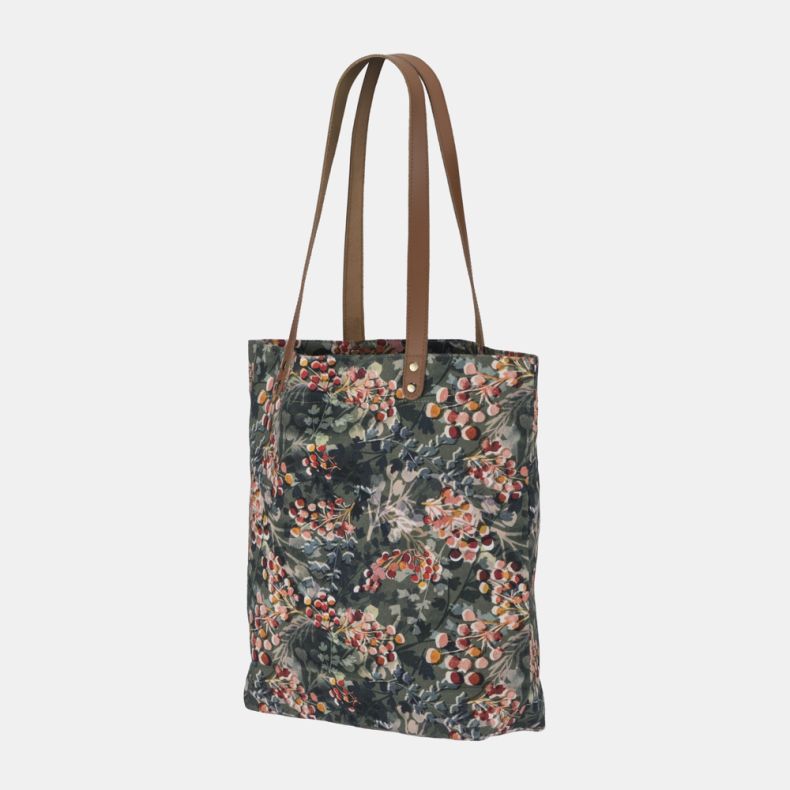 Floral print tote bag with tan shoulder straps and all-over botanical berry pattern shown from an angled side view.