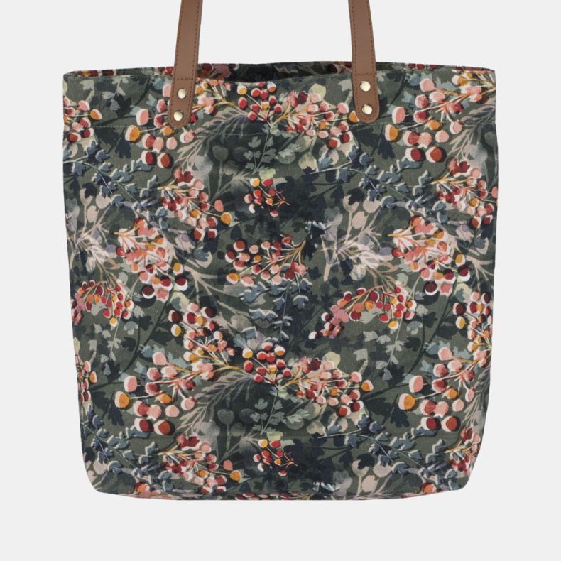 Floral print tote bag featuring a leafy botanical and berry pattern with tan shoulder straps and spacious open-top design.