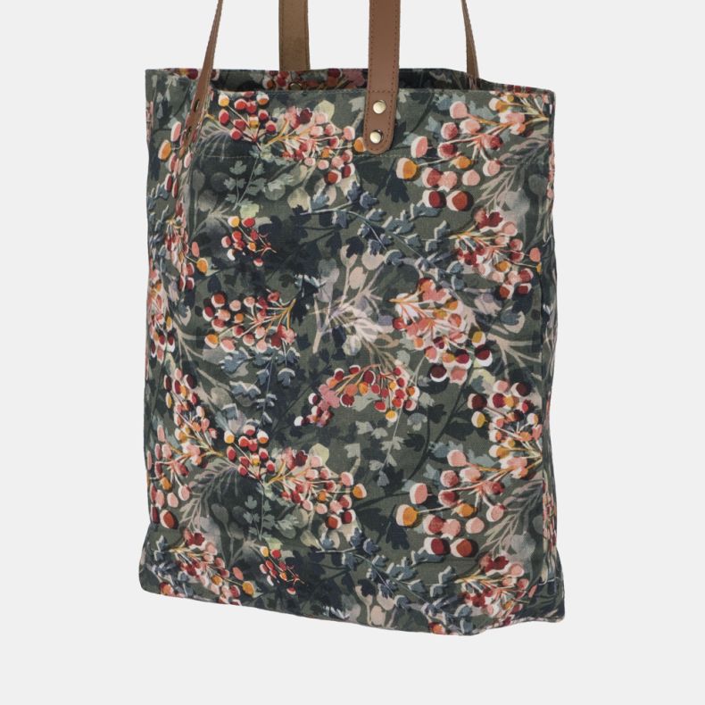 Floral print tote bag with tan shoulder straps and all-over botanical berry pattern shown from an angled rear view.