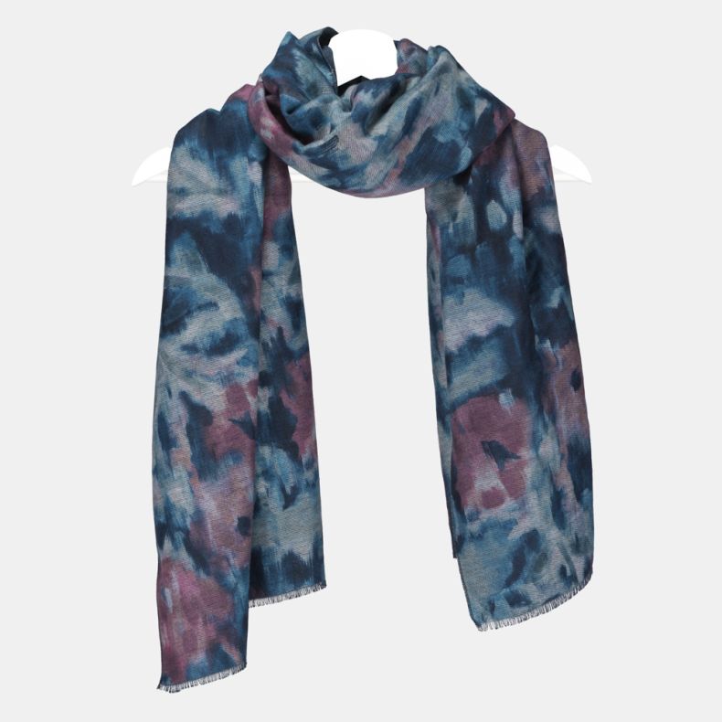 Abstract watercolor print scarf in shades of blue, teal and mauve, featuring a soft brushed texture, fringed edges, and long rectangular design draped on a hanger.