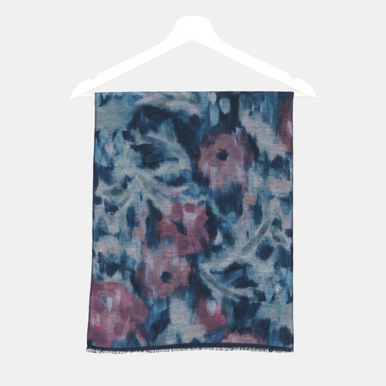 Abstract watercolor print scarf folded on a hanger, featuring blended blue, teal and mauve tones with a soft brushed texture and fringed edge detail.