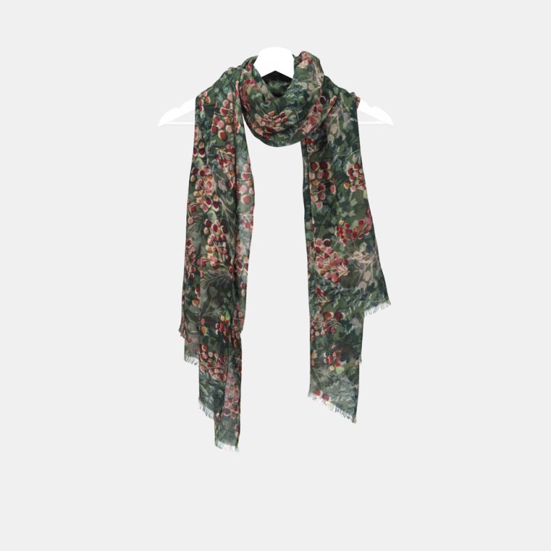 Green botanical print scarf with an all-over foliage and berry pattern in shades of green, red and pink, featuring soft lightweight fabric, fringed edges, and a long rectangular design draped on a hanger.
