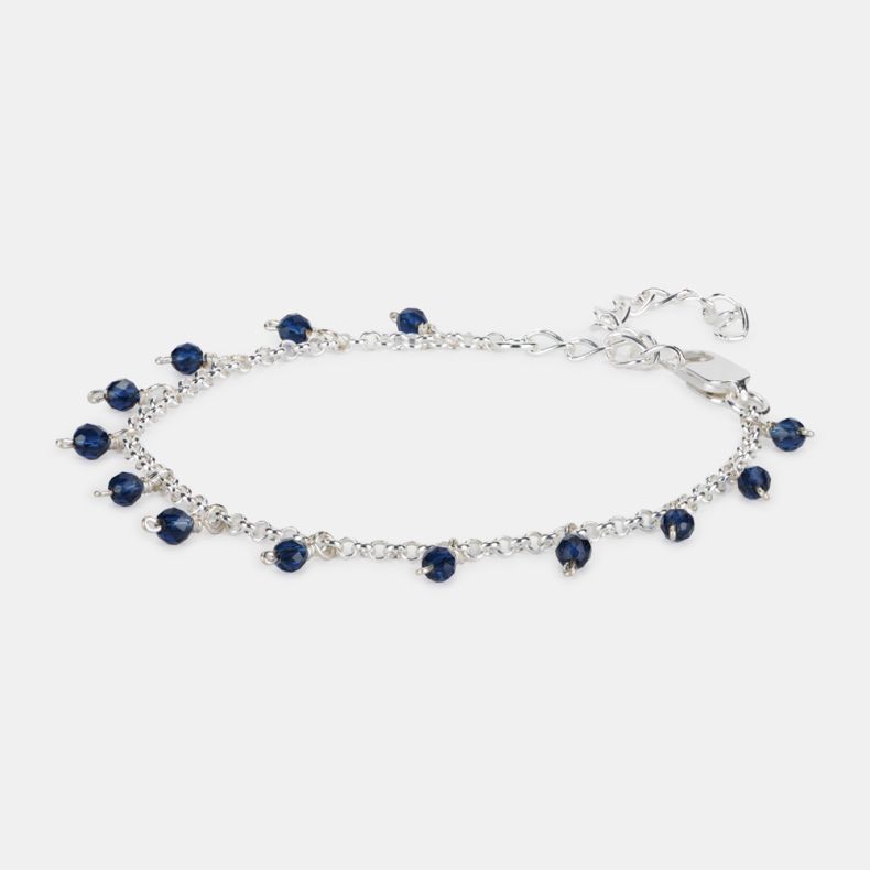 Silver-tone charm bracelet featuring faceted navy blue crystal bead drops, a delicate chain design, adjustable extender links, and lobster clasp fastening.