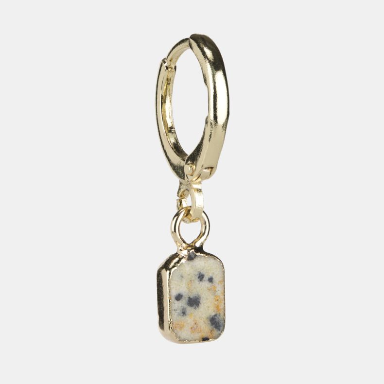 Gold-tone huggie hoop earring with a rectangular speckled stone drop charm, featuring a cream-toned natural stone design with grey, black and warm beige fleck detailing shown from an angled side view.