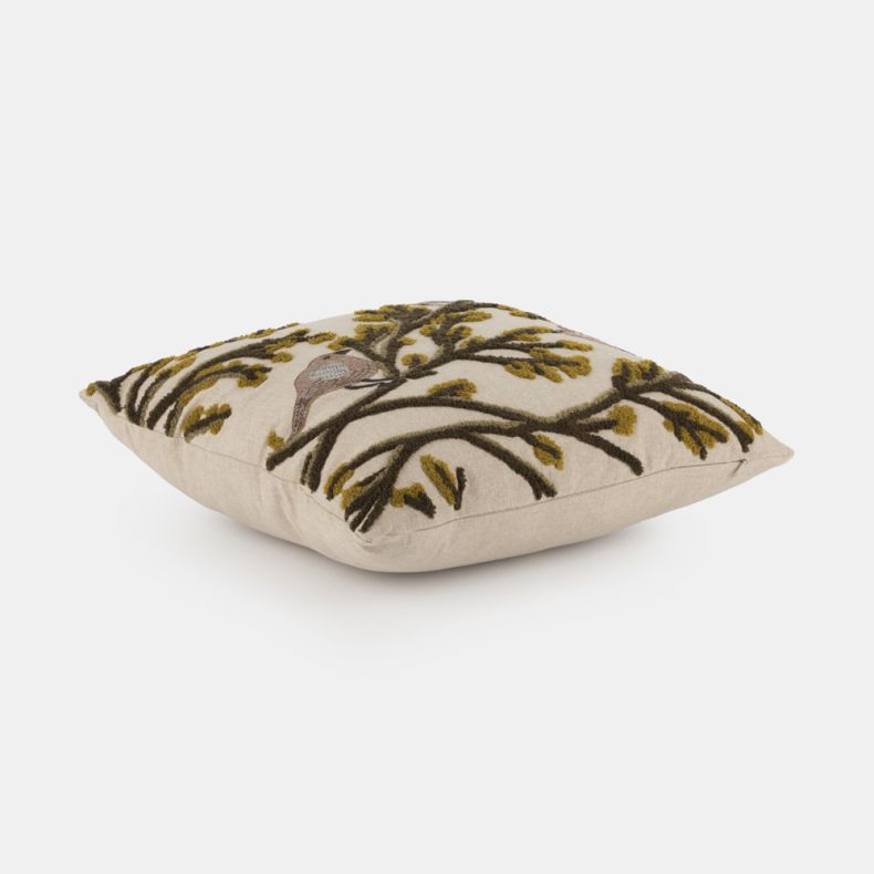 Side view of a square cushion featuring embroidered and tufted birds perched among decorative branches on a soft neutral background. Textured detailing in warm brown and mustard tones adds depth and dimension, while the plush filling creates a full, cosy 