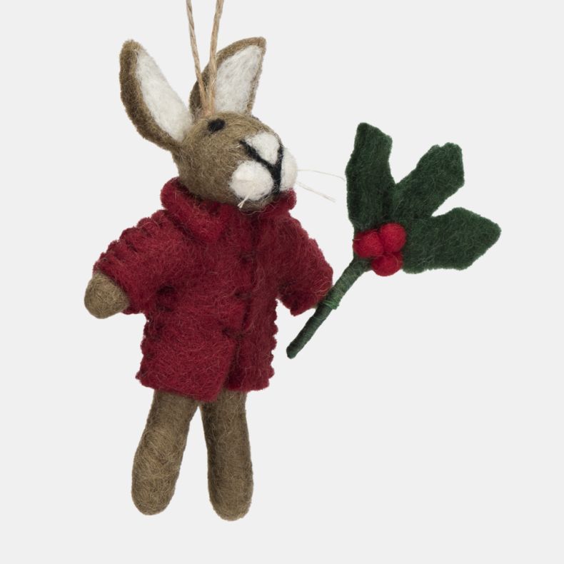 Felt hare Christmas hanging decoration shown in a close-up angled side view, featuring a grey-brown wool-effect body, bright red coat, and a holly sprig with red berries, finished with handcrafted needle-felted detailing and a rustic twine hanging loop.