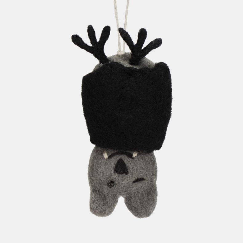 Felt bat hanging decoration with a grey felt body, black folded wings, and a playful winking expression. Finished with black felt ears, small white fangs, and a natural hanging loop, making it a charming Halloween ornament for seasonal displays, tree deco