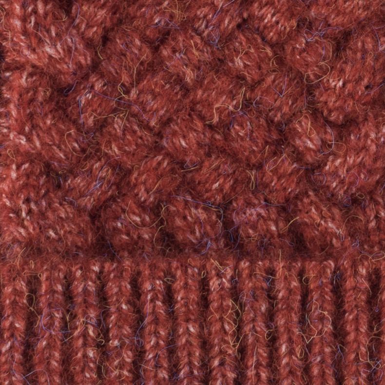 Close up of rust orange textured cable-knit material.