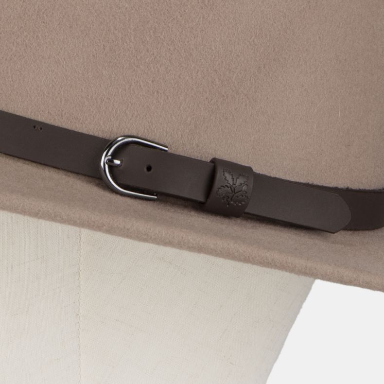 Close-up detail of a taupe felt fedora-style hat, highlighting the dark brown faux leather band and buckle fastening. The strap keeper features an embossed National Trust oak leaf logo, adding a subtle heritage-inspired detail to the classic design. The s