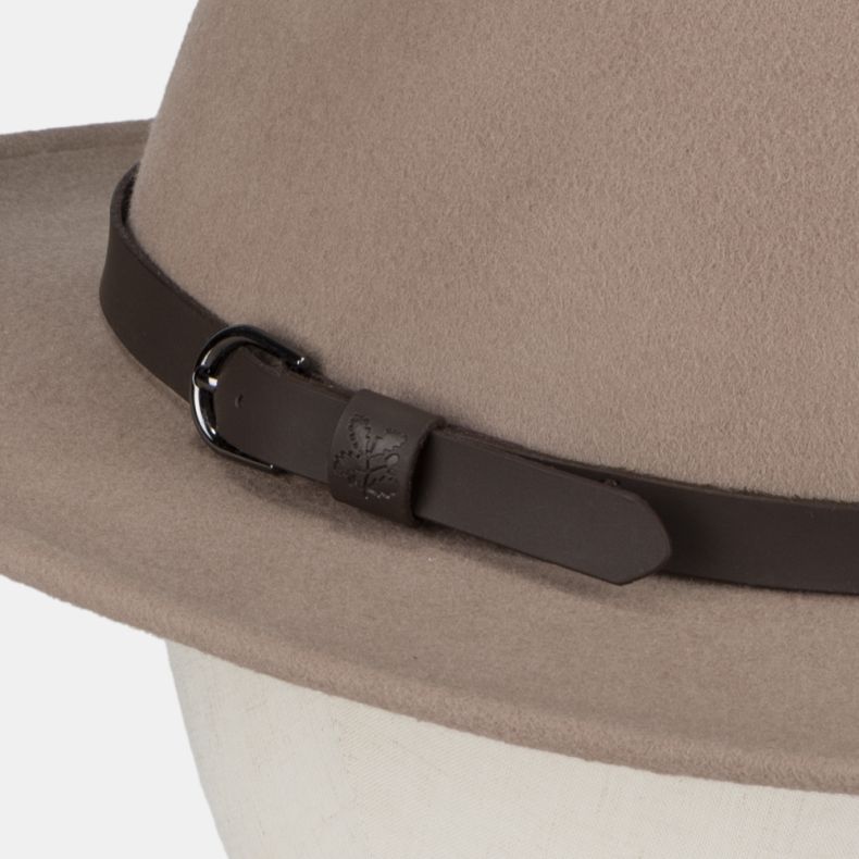 Close-up detail of a taupe felt fedora-style hat, highlighting the dark brown faux leather band and buckle fastening. The strap keeper features an embossed National Trust oak leaf logo, adding a subtle heritage-inspired detail to the classic design. The s