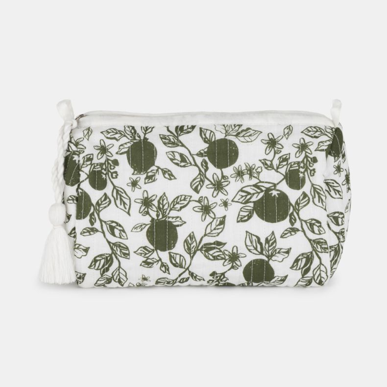 White quilted toiletry bag featuring a green orangery-inspired print with citrus fruit, leaves, and blossoms. The zip-top design includes a decorative white tassel pull and a softly structured shape, photographed against a light grey background.