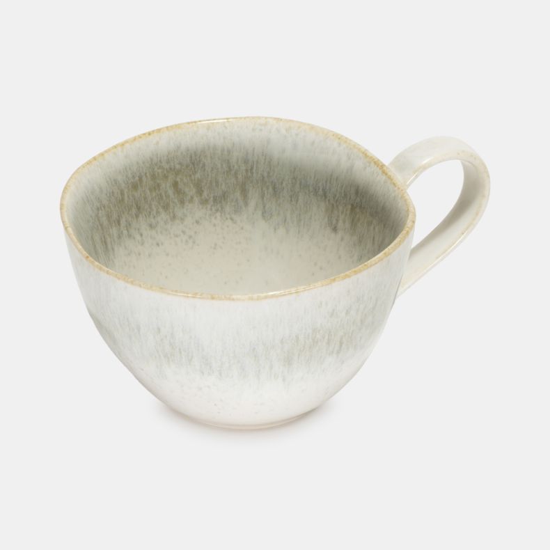 Top view of the Speckled Mist Mug, featuring a soft off-white reactive glaze with delicate speckled detailing and subtle mist-like tonal variations throughout the interior and exterior. The elegant stoneware design is finished with a slender curved handle